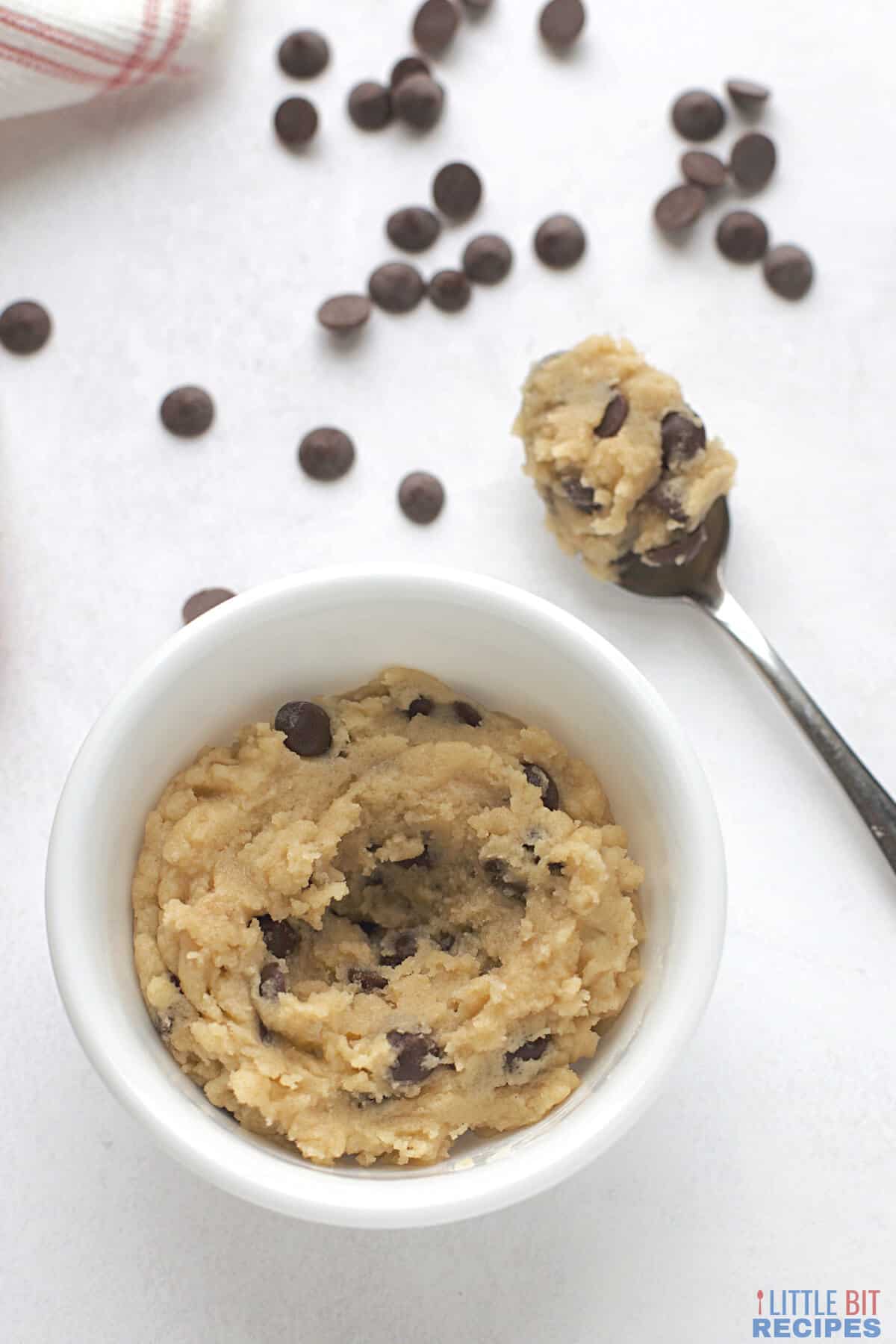 edible chocolate chip cookie dough in bowl and on spoon.