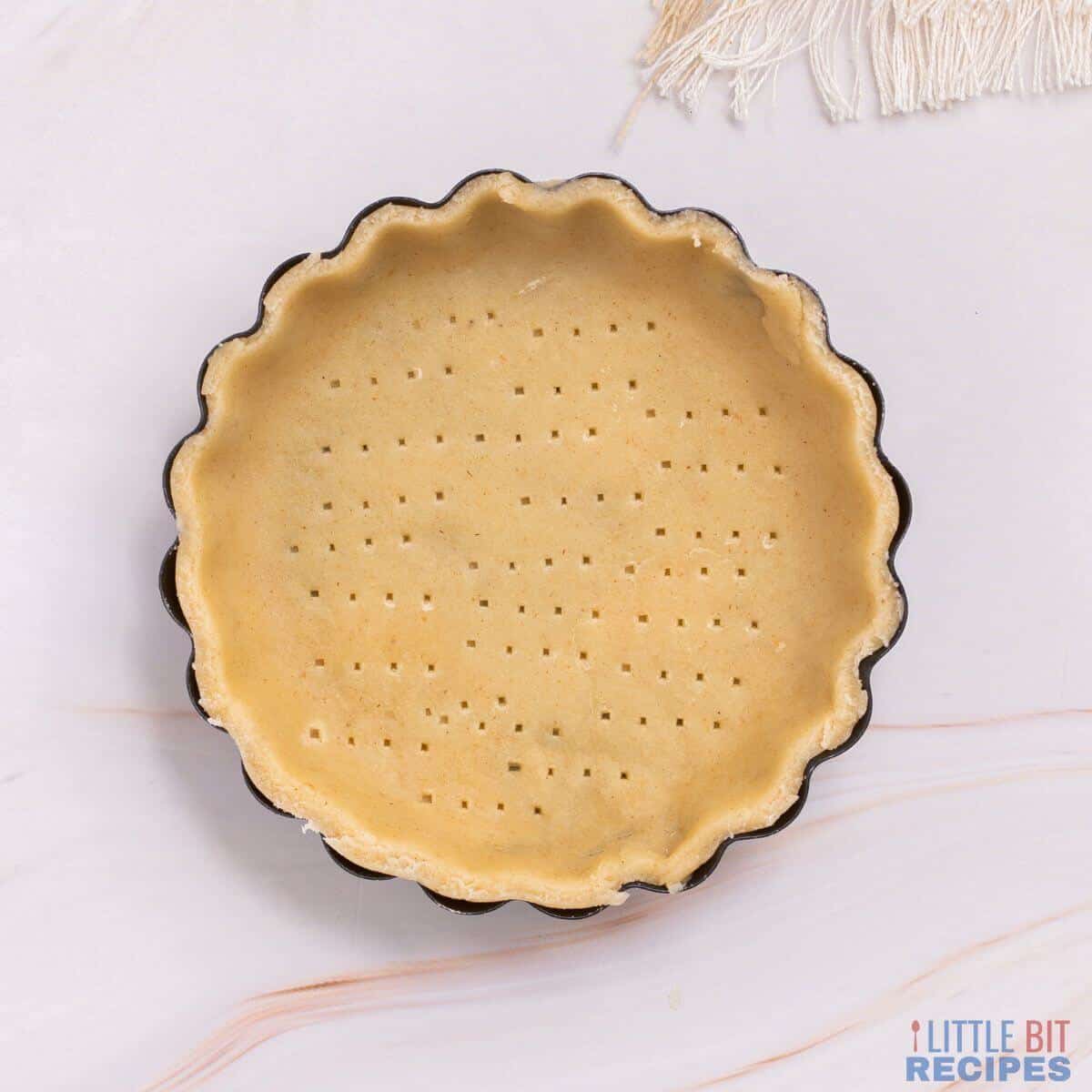 bottom pie crust in pan with fork pricks.