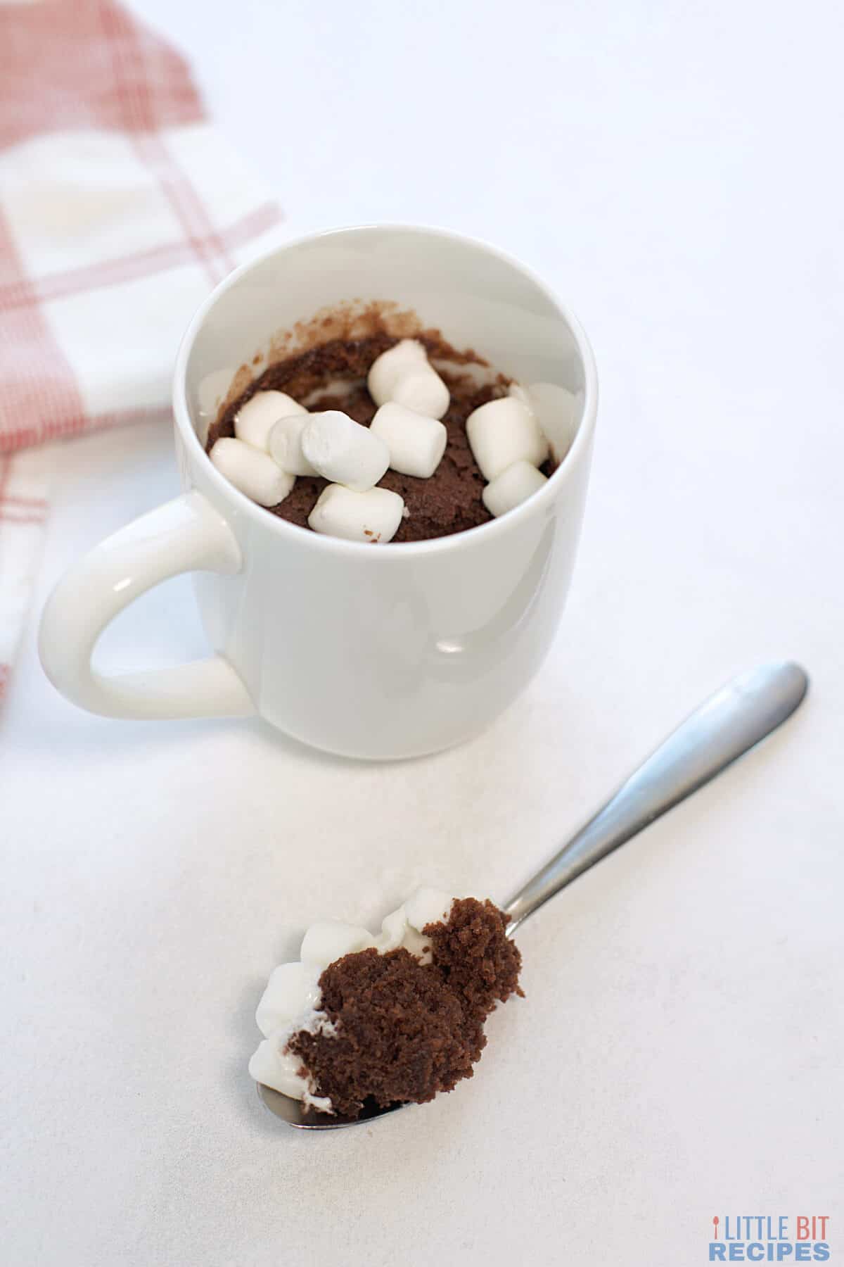 hot chocolate mug cake with spoonful on table.