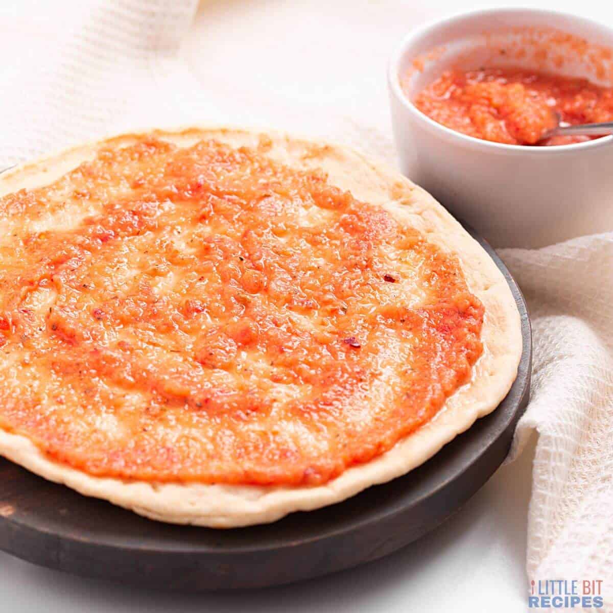 pizza sauce spread on crust.