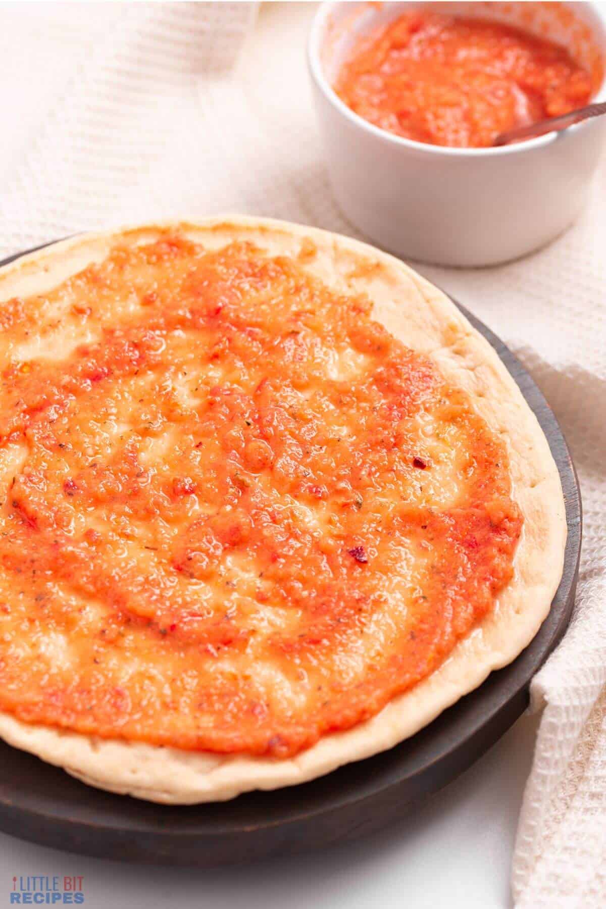 sauce spread on pizza crust.
