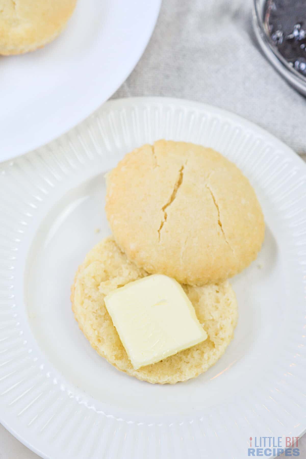 sliced biscuit on plate with butter.