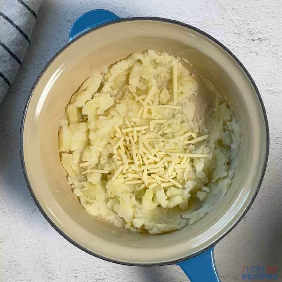 adding cheese to mashed potato.