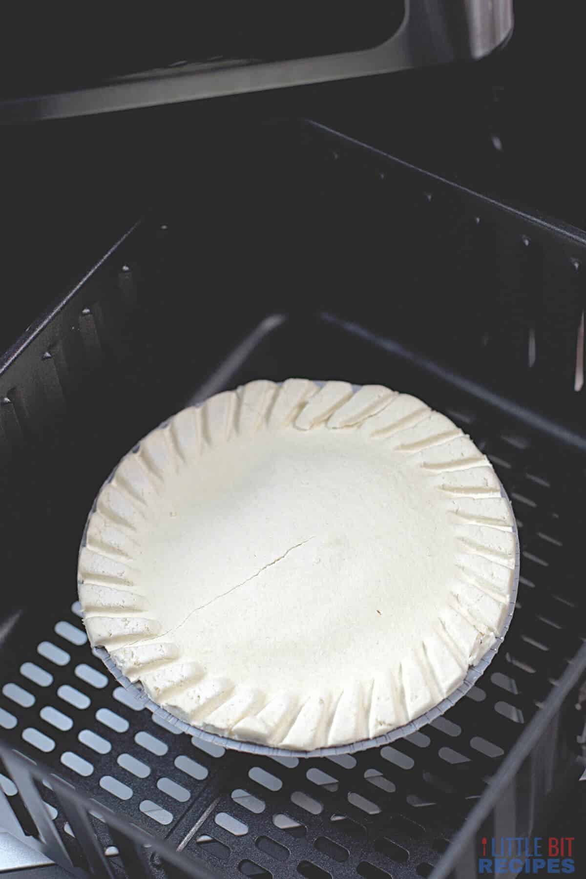 frozen pot pie in air fryer basket.