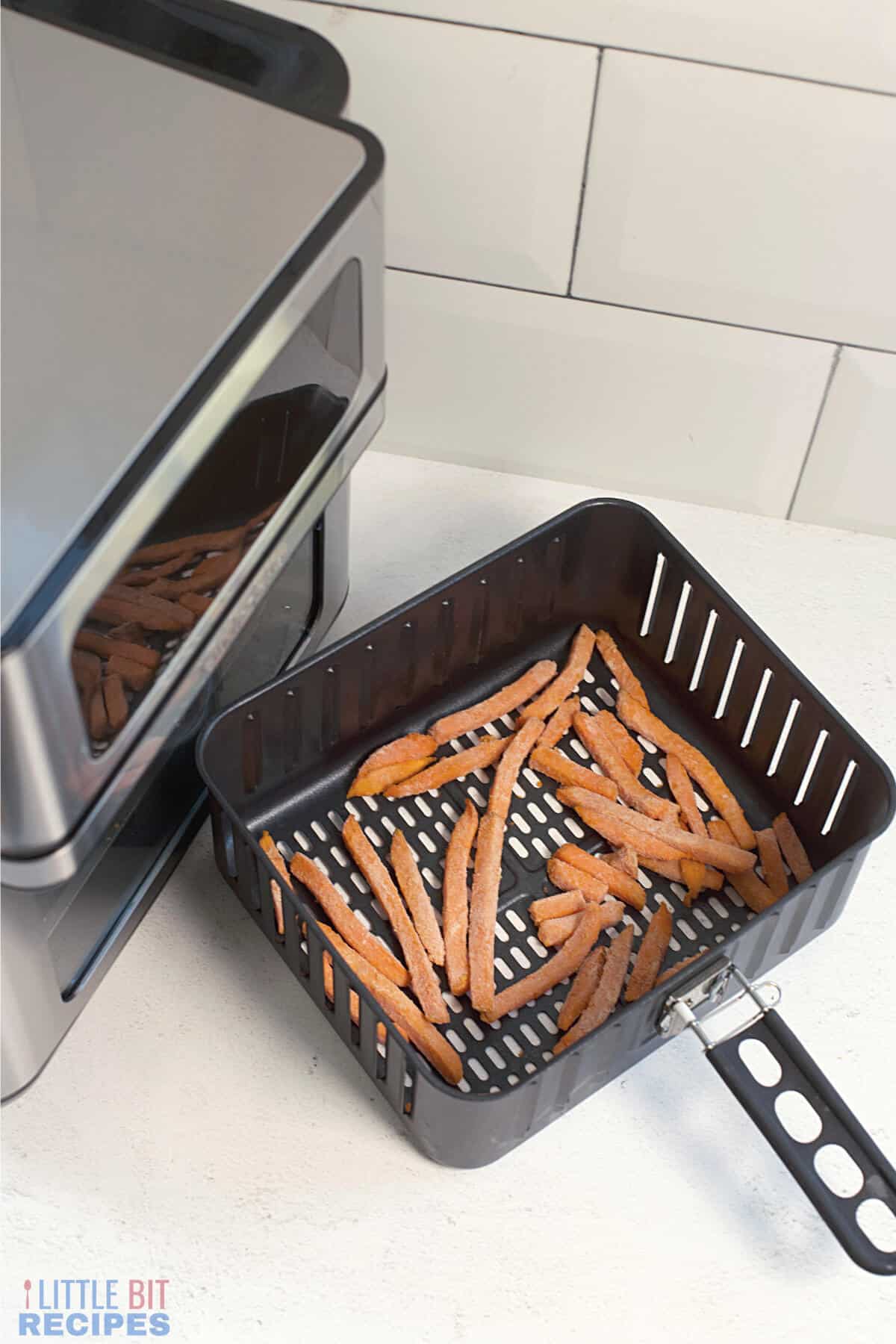 frozen sweet potatoes in air fryer basket.