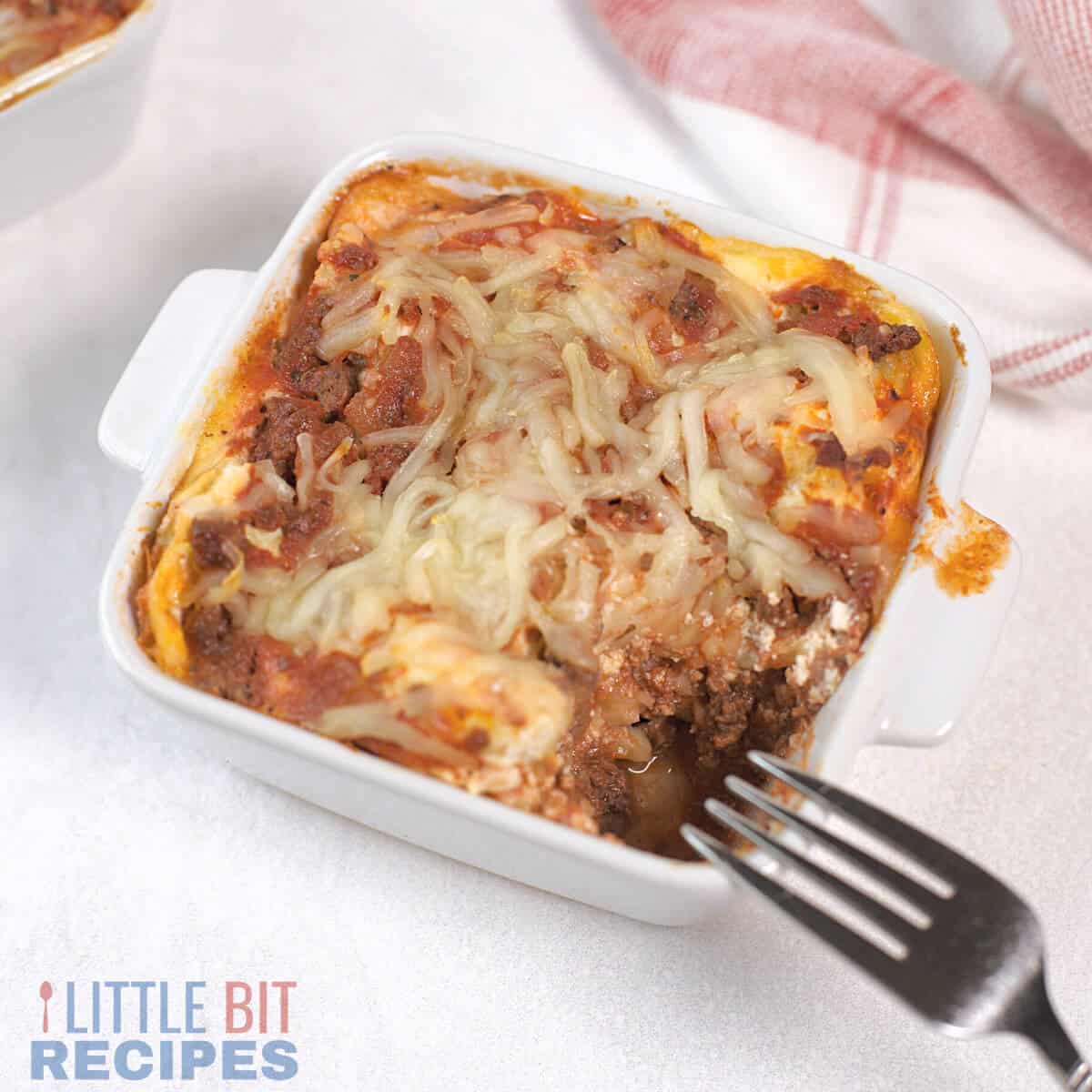 individual lasagna in small square baking dish.