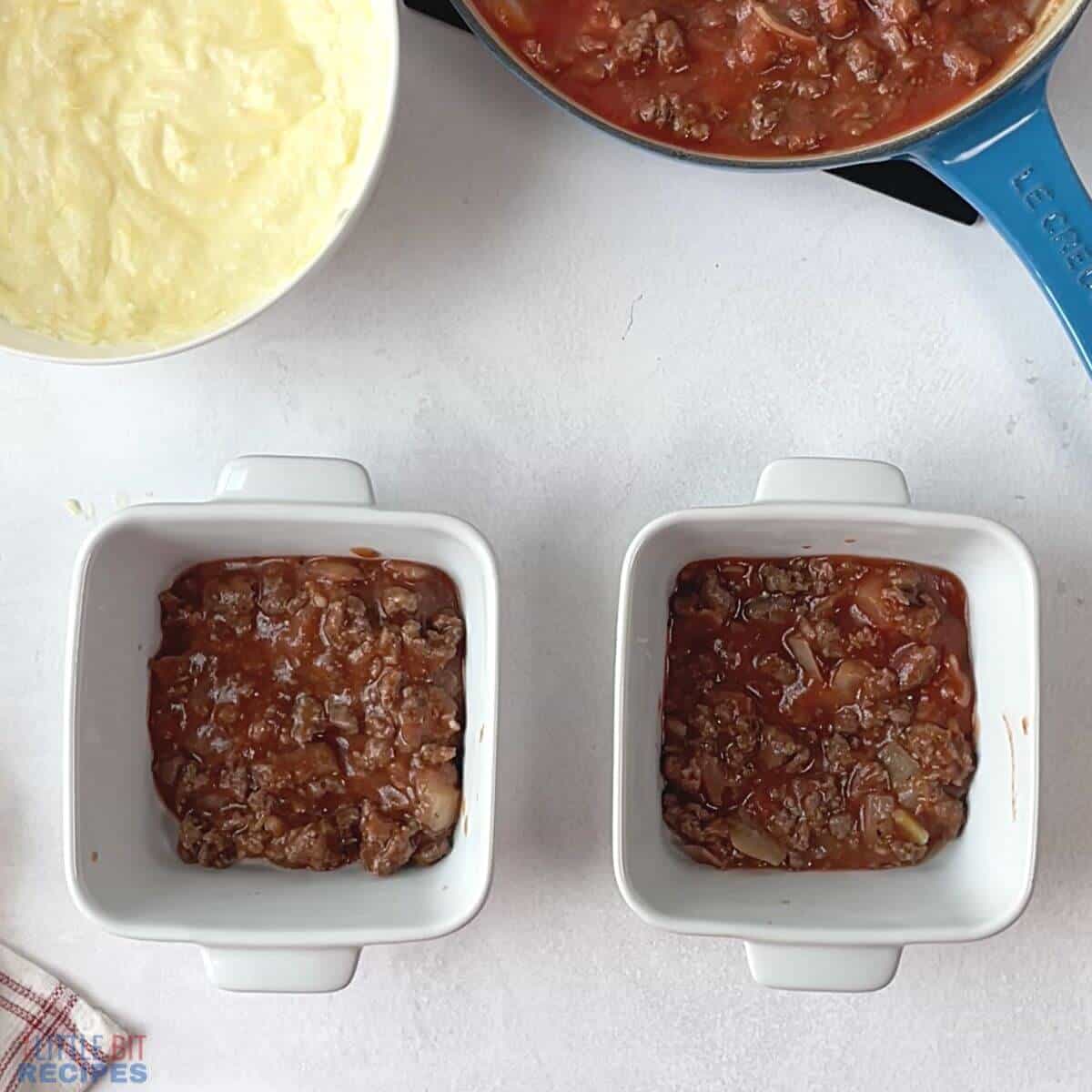 meat sauce layer in mini baking pans.