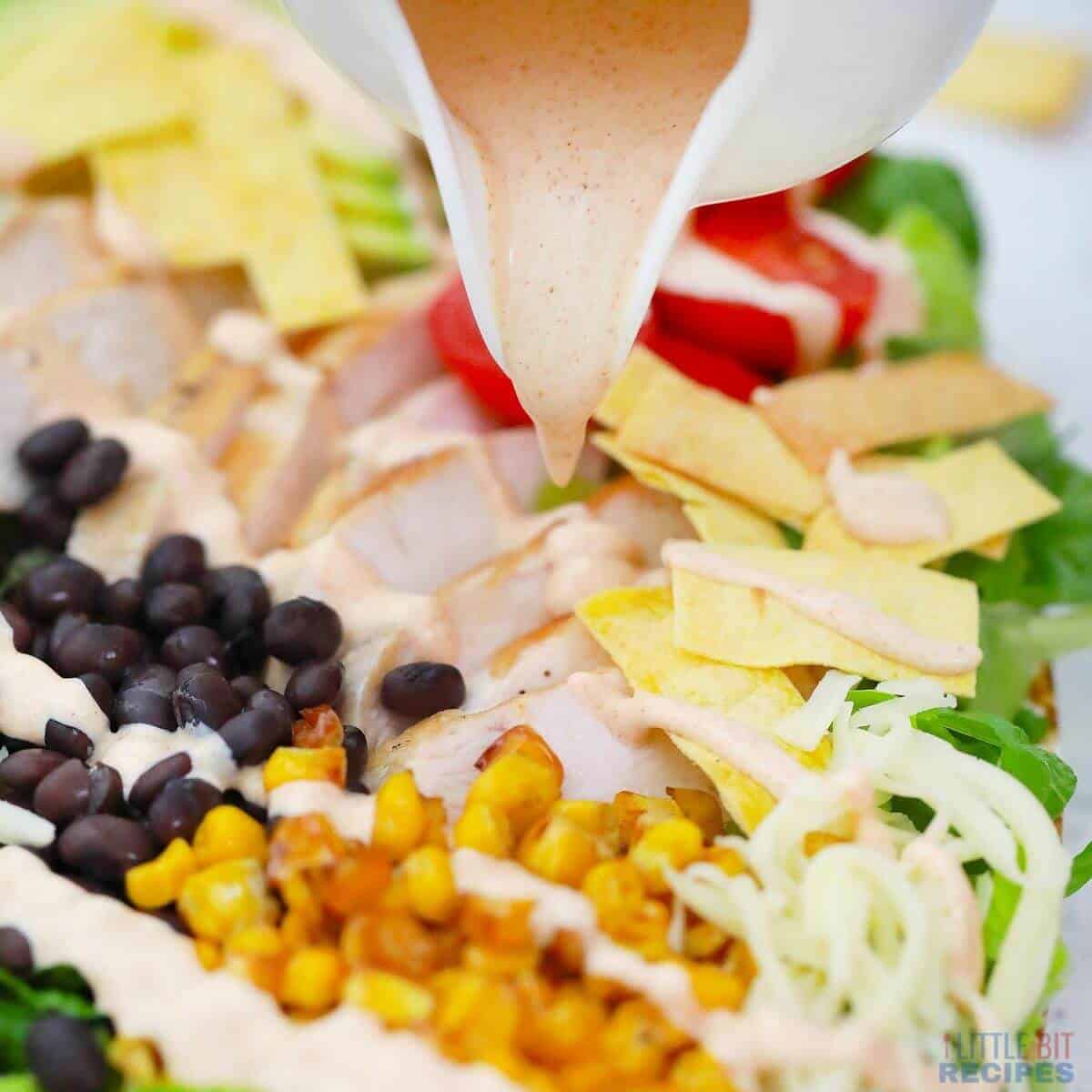 pouring dressing over salad.