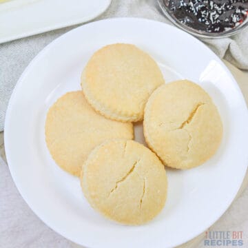 four biscuits on a white plate.