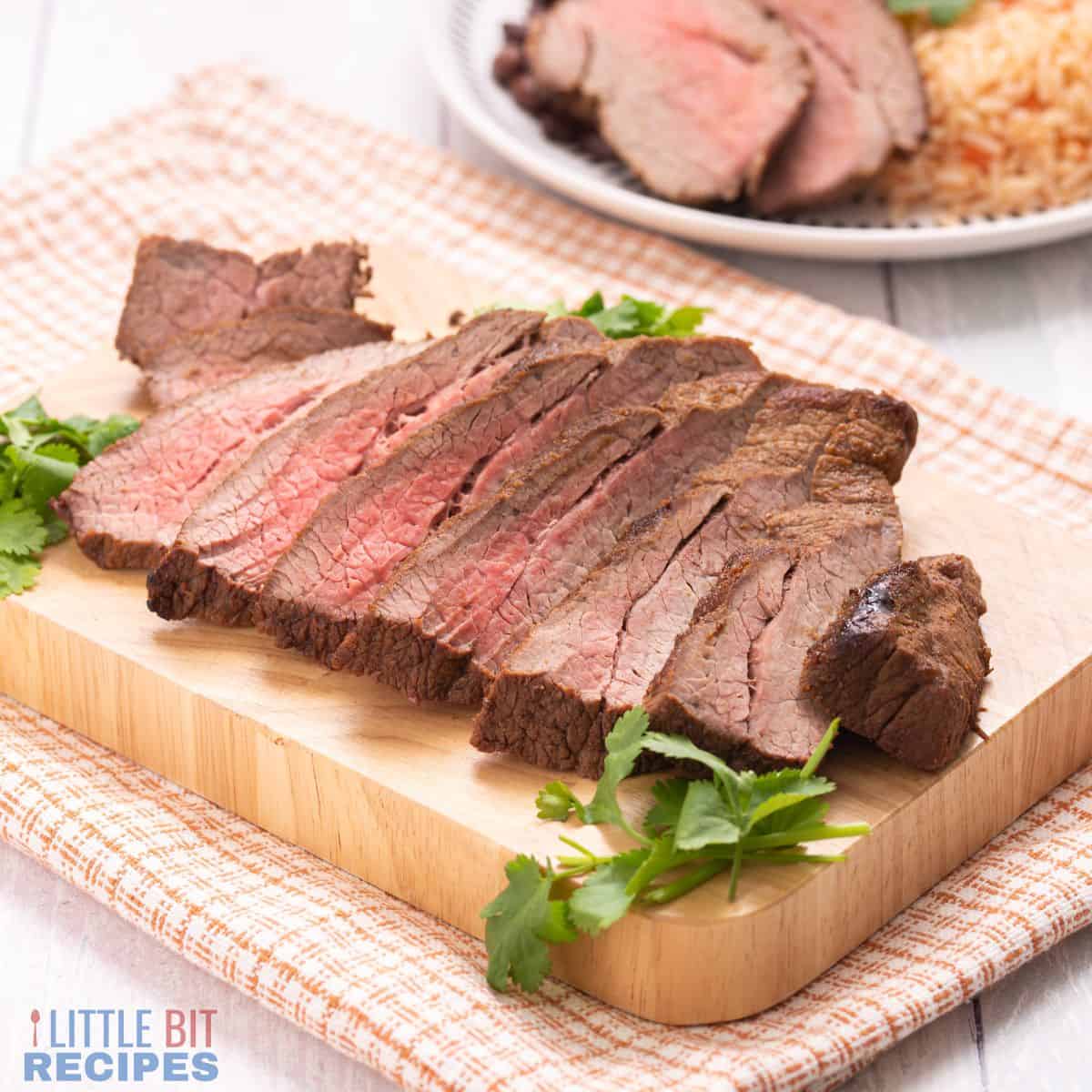 sliced carne asada on cutting board.