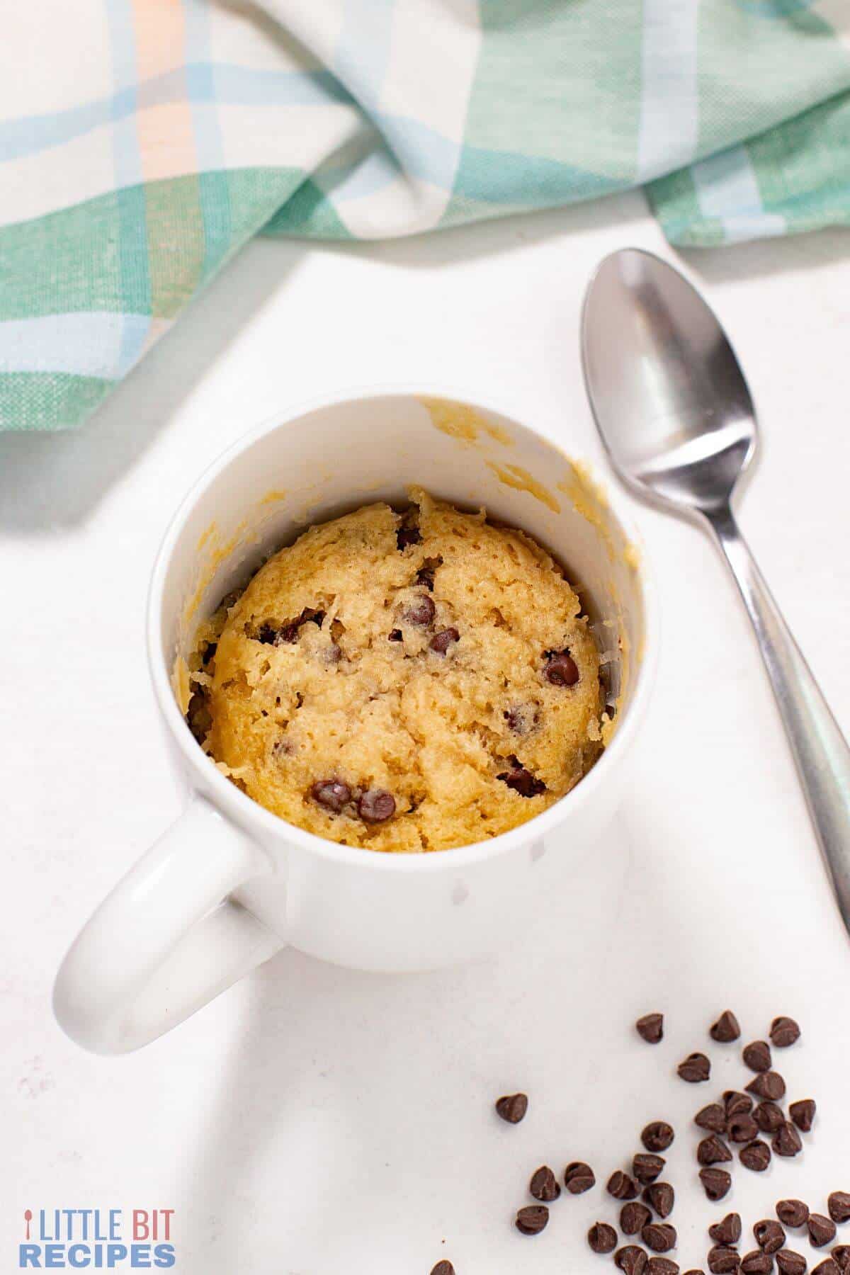 chocolate chip mug cake with spoon and chips.