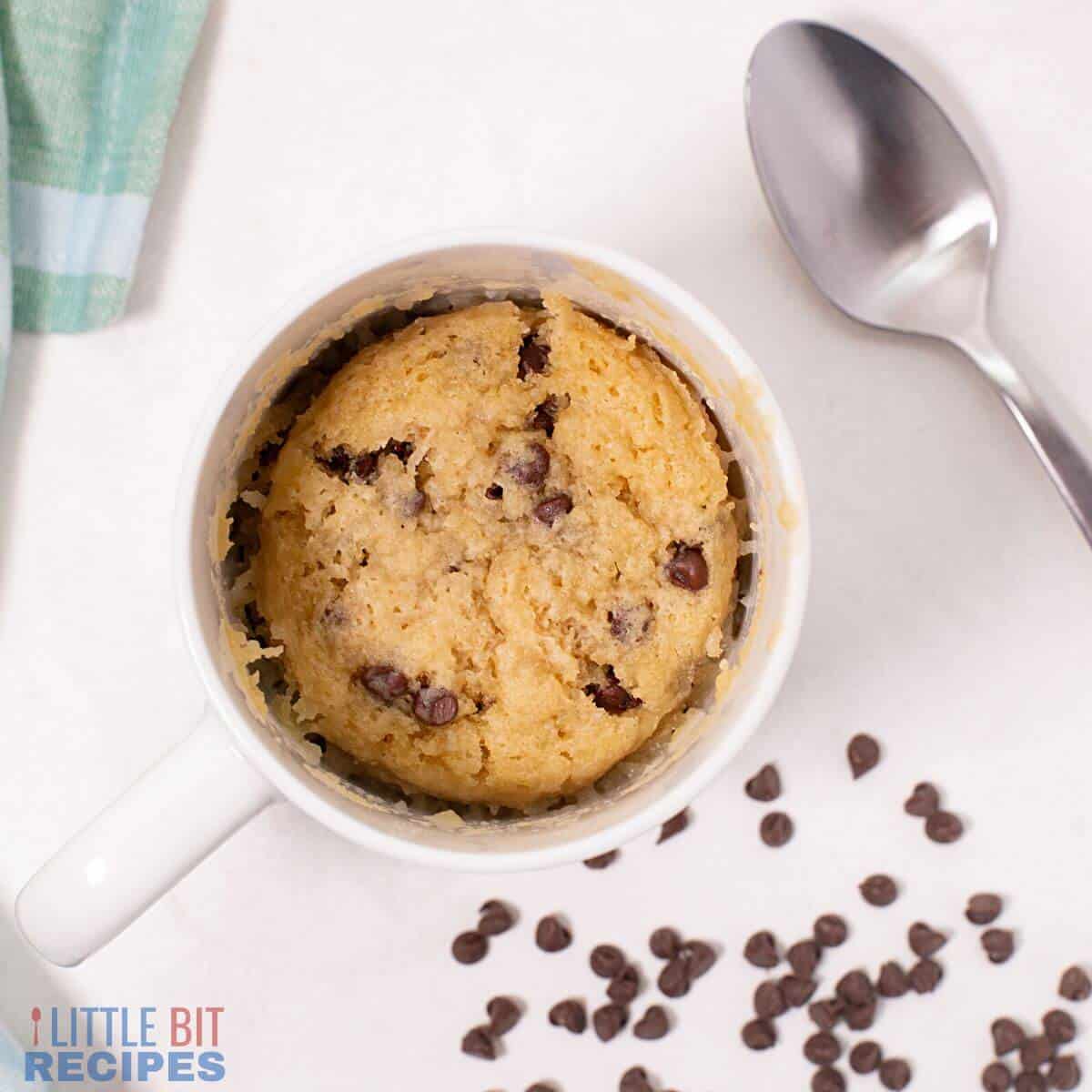 chocolate chip mug cake with spoon and chips.