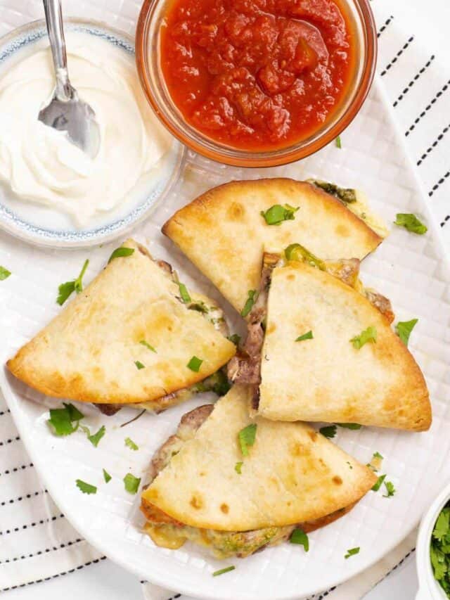 beef steak quesadillas with salsa and sour cream.