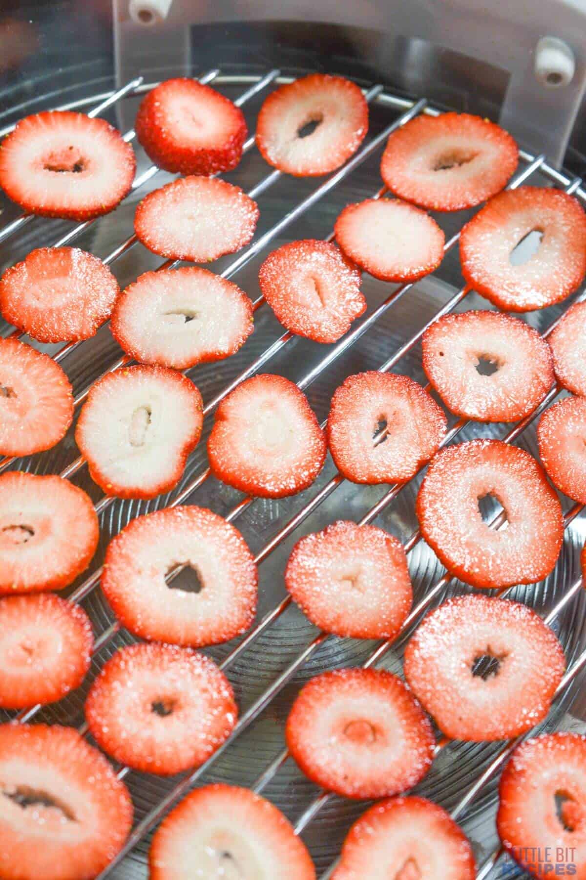 slices of strawberries on rack in air fryer.