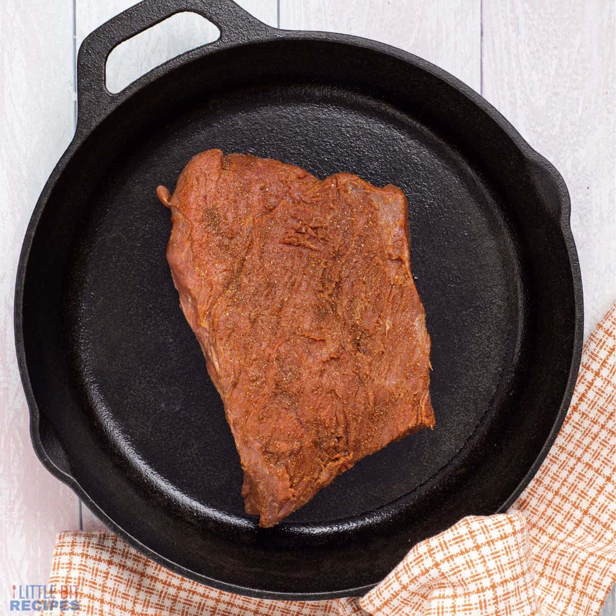 seasoned steak in cast iron skillet.