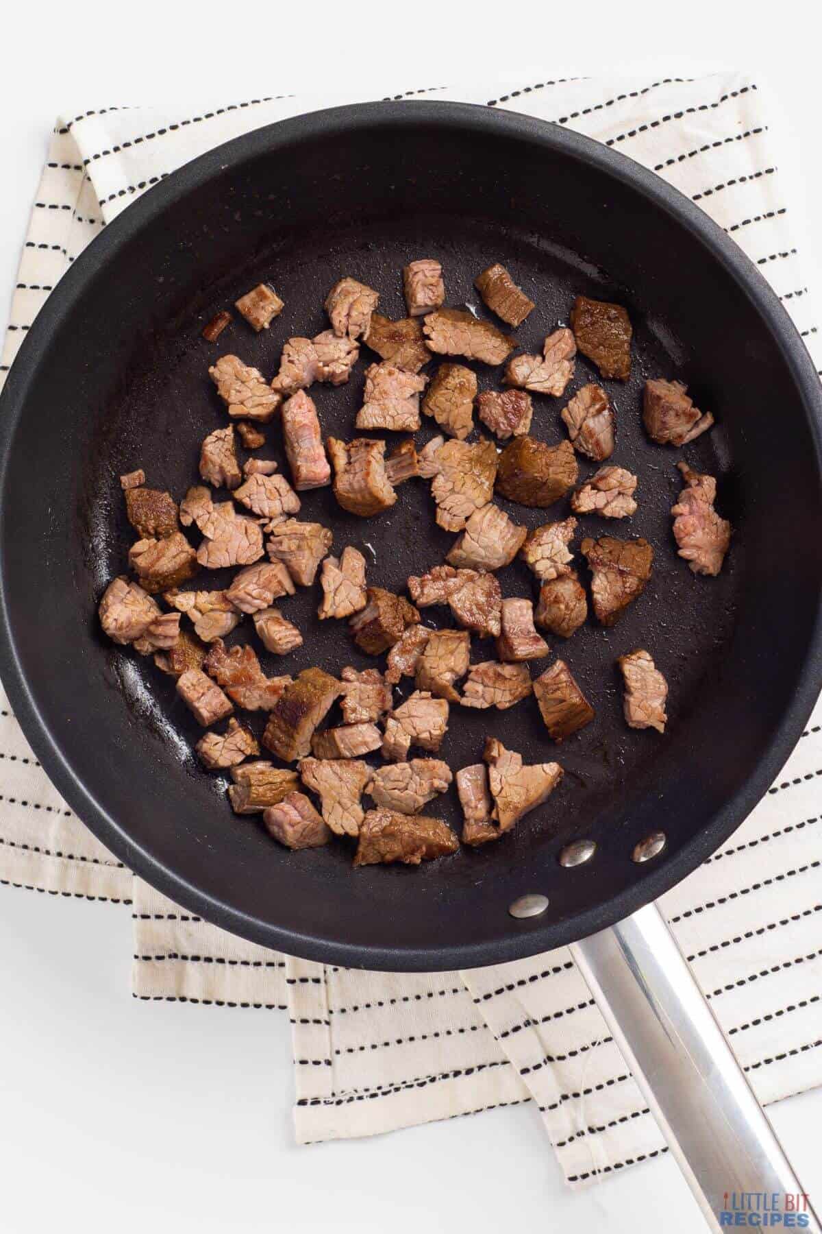 steak pieces in pan.