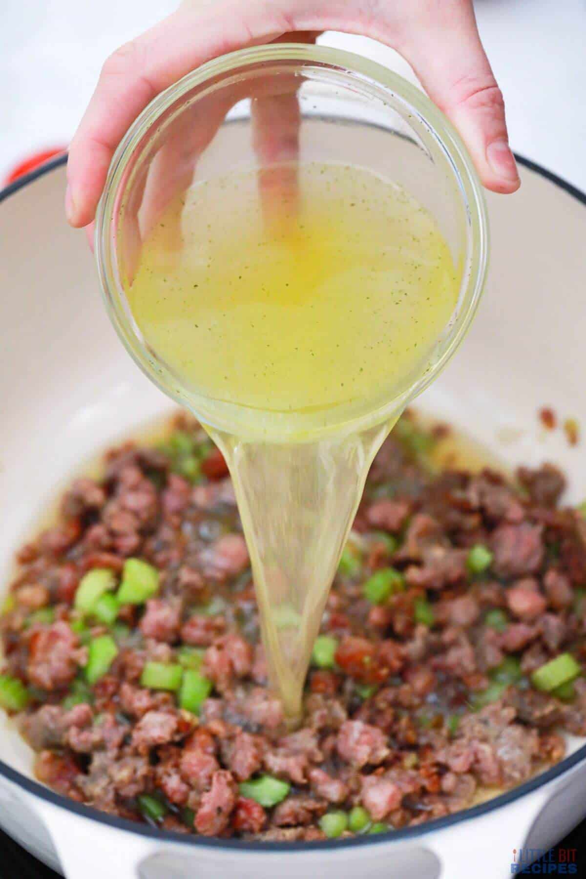 adding broth into pot.