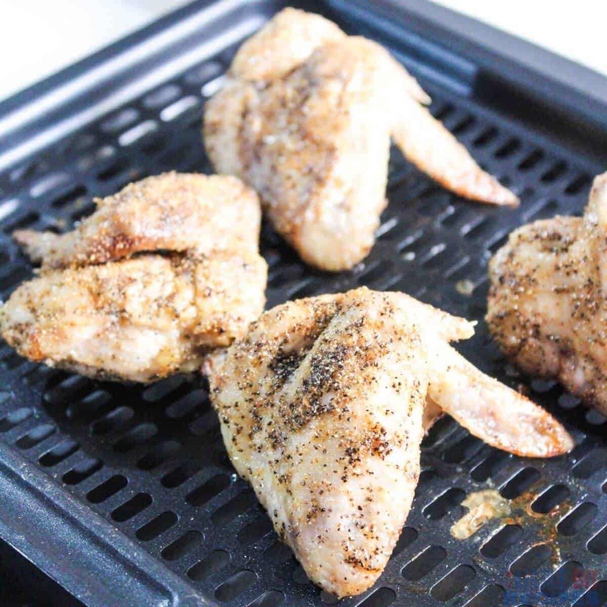 cooking partially cooked seasoned wings in air fryer.