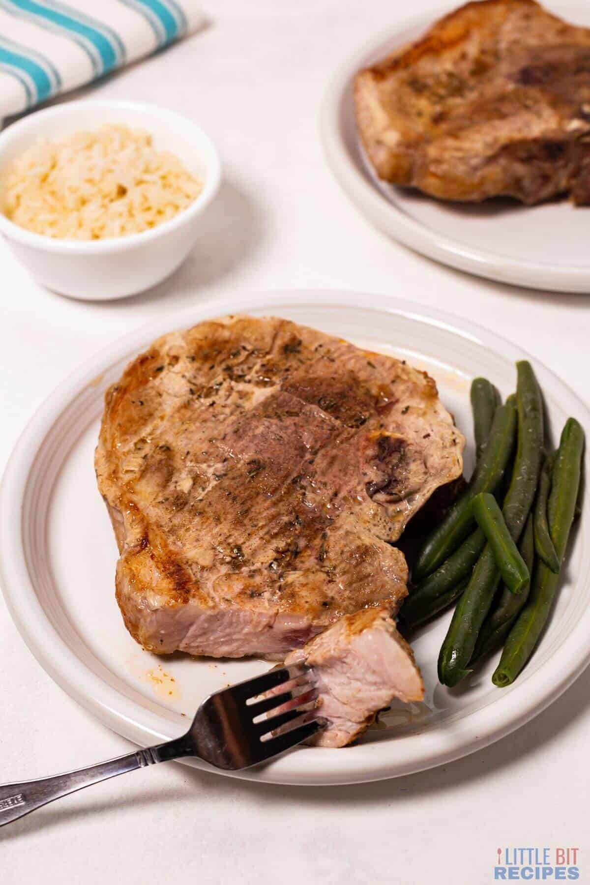 baked pork steaks with fork bite.