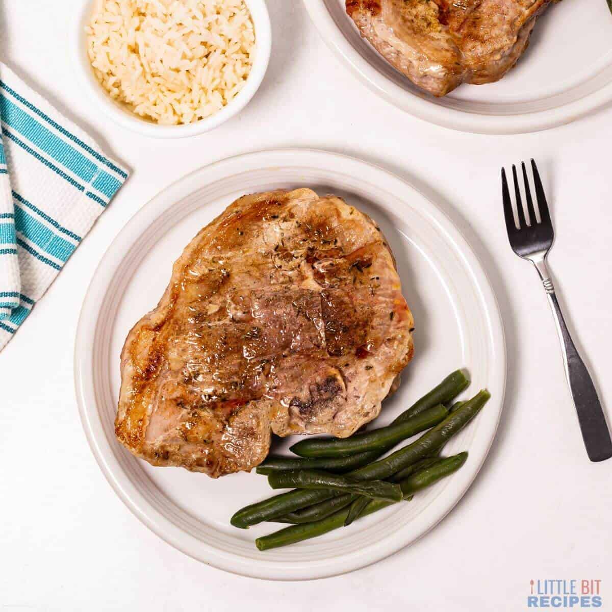 oven baked pork steaks on plates.