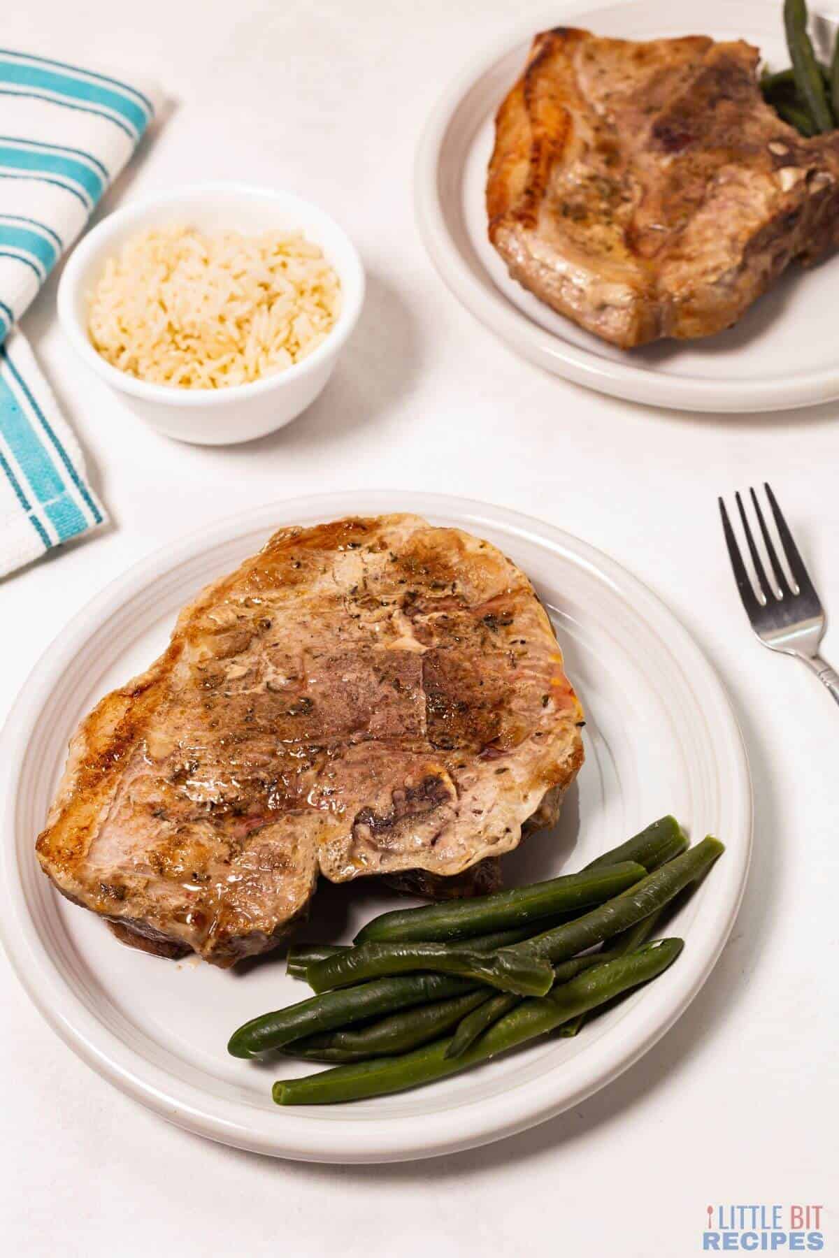 baked pork steaks with green beans and rice.