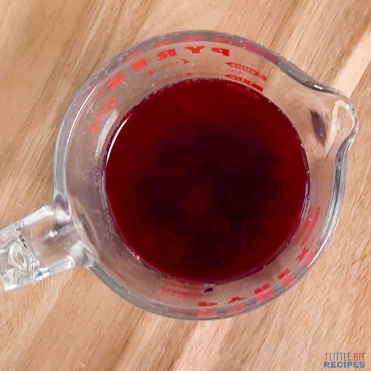 tea sitting with blackberry mixture on wood board.