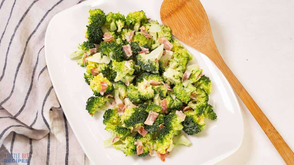 platter of broccoli salad with wooden spoon.