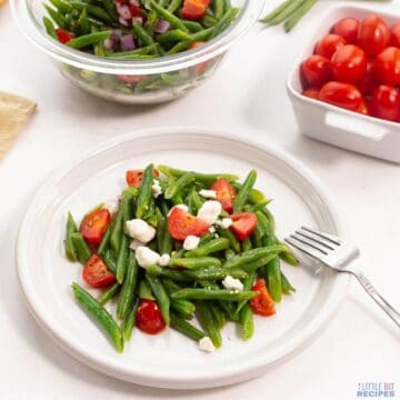 green bean tomato salad on plate with fork.