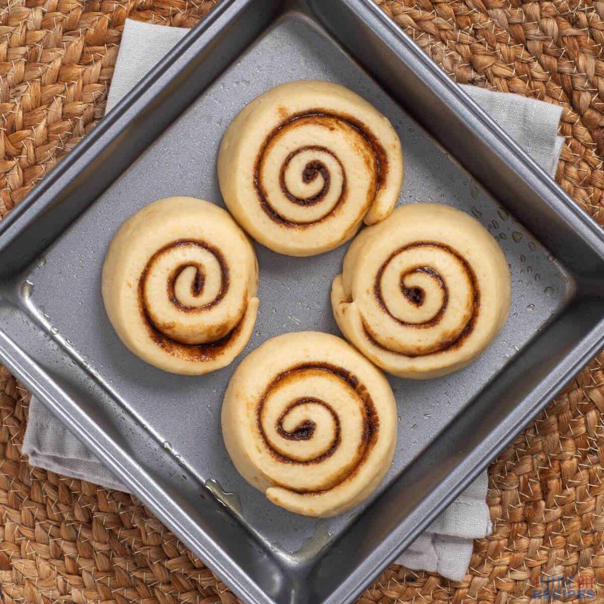 unbaked cinnamon rolls in baking pan.