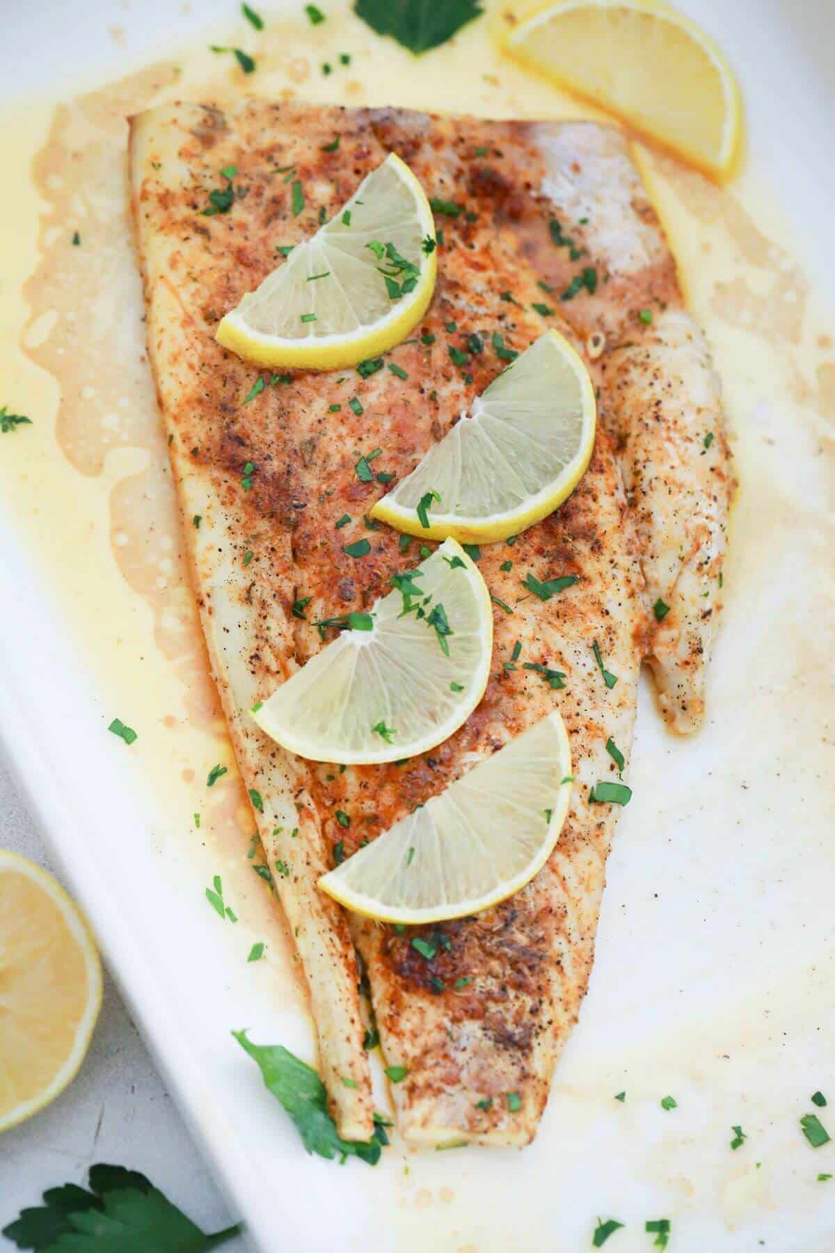 baked fish fillet topped with lemon slices.
