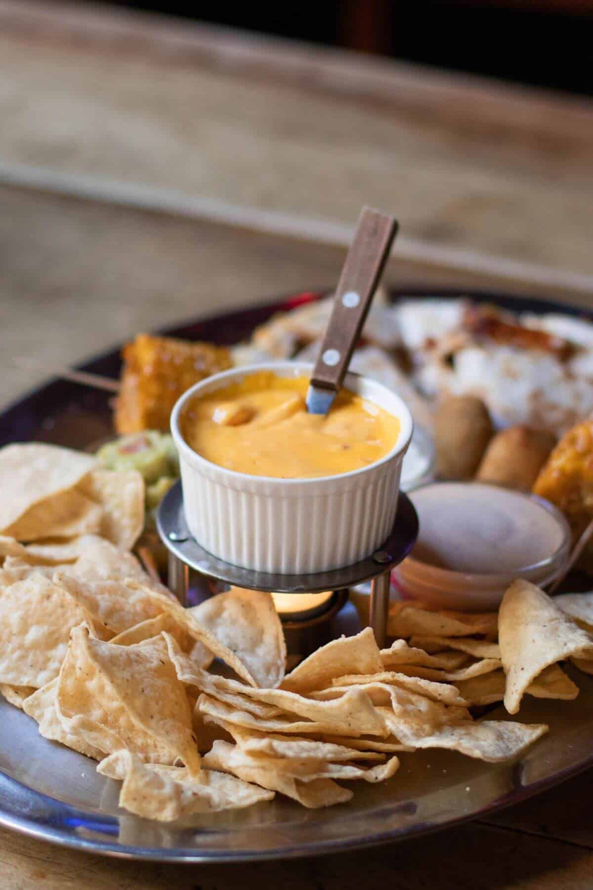 appetizer platter with tortilla chips and cheese dip.