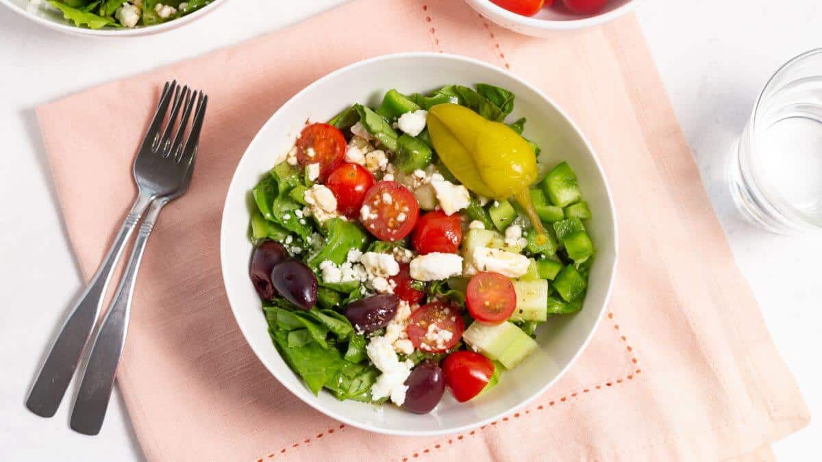 chopped greek salad in white serving bowl.
