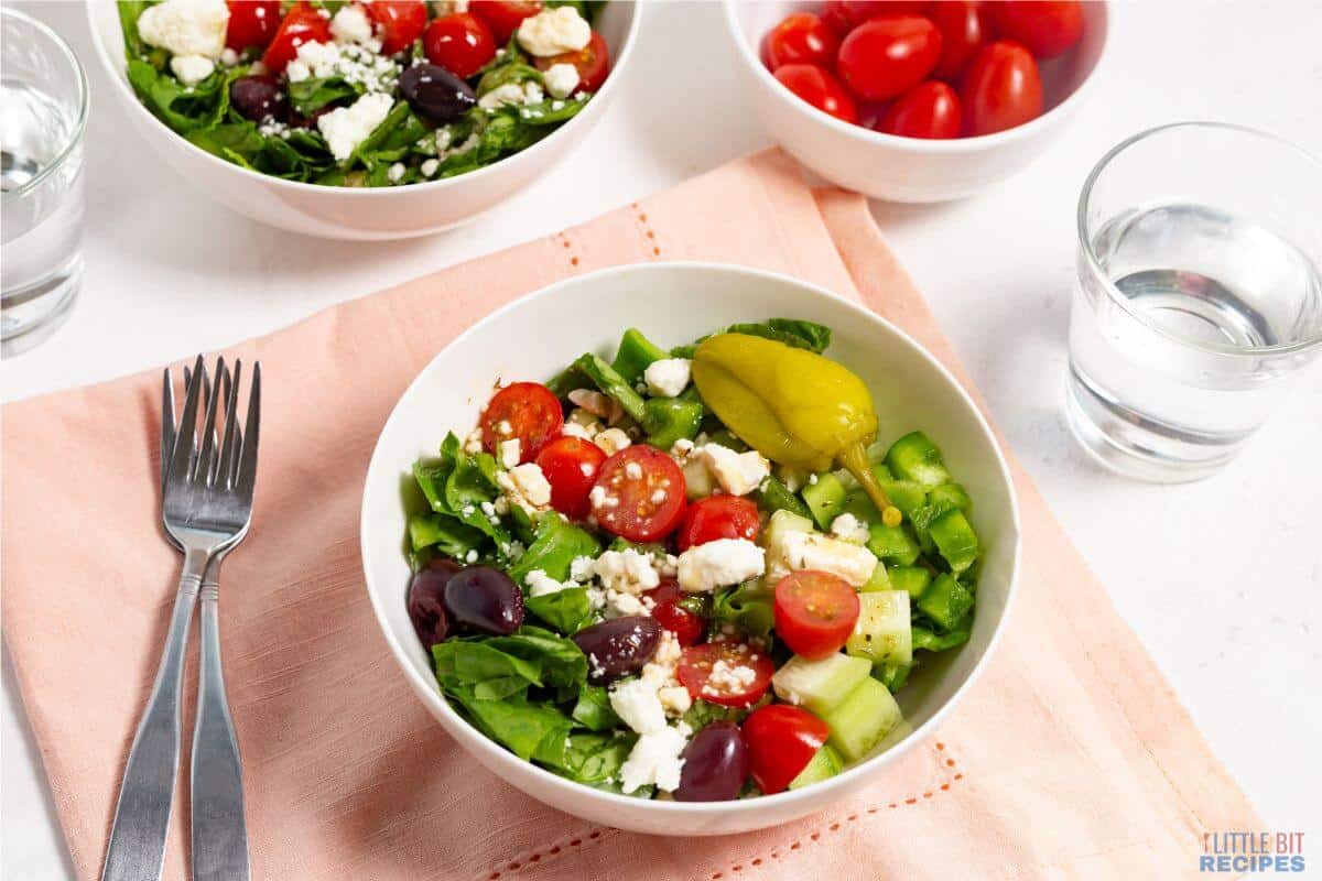 chopped greek salad in two white bowls.