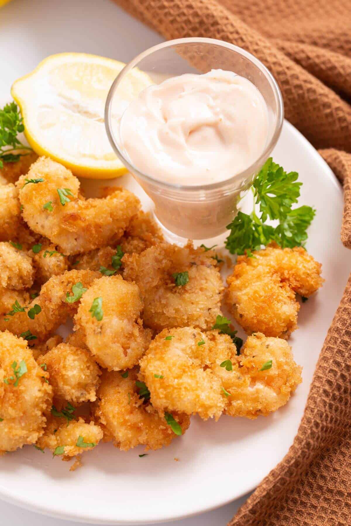serving panko shrimp on plate with dipping sauce.