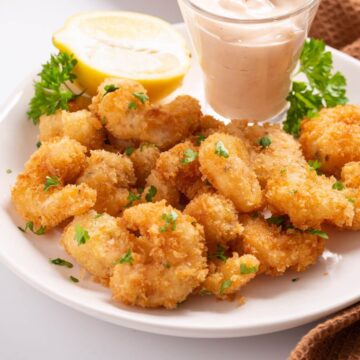 panko shrimp served with dipping sauce and lemon.