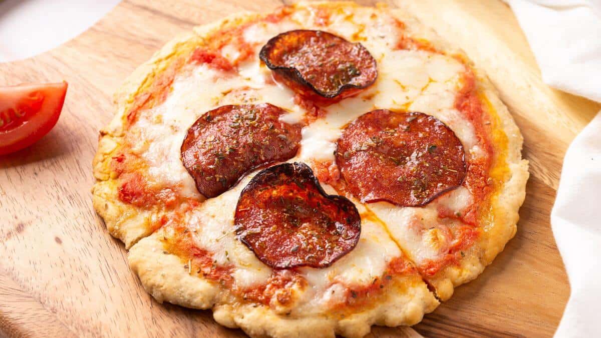 Single serve pepperoni pizza on wooden cutting board.