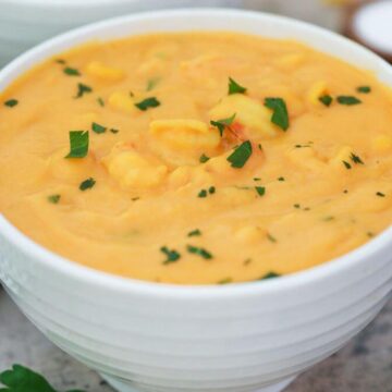 shrimp corn soup in white bowl.
