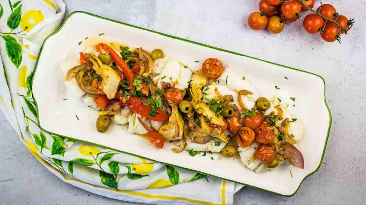 Mediterranean Cod on platter with tomatoes.