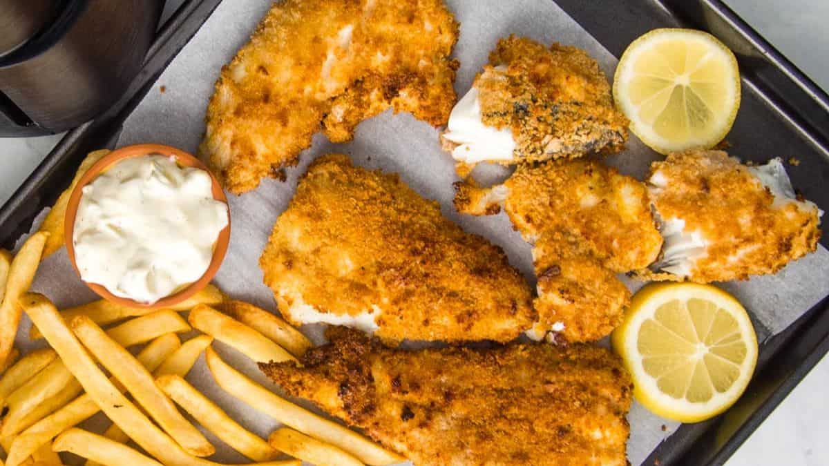 Air fryer fish and chips on lined sheet pan.