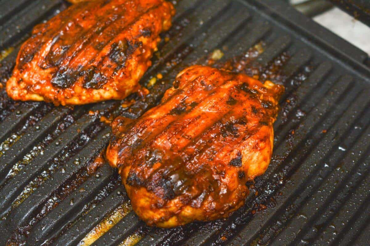 bbq boneless chicken thighs on grill.