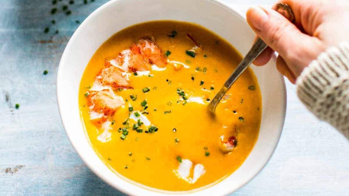 Classic creamy lobster bisque in a white bowl.
