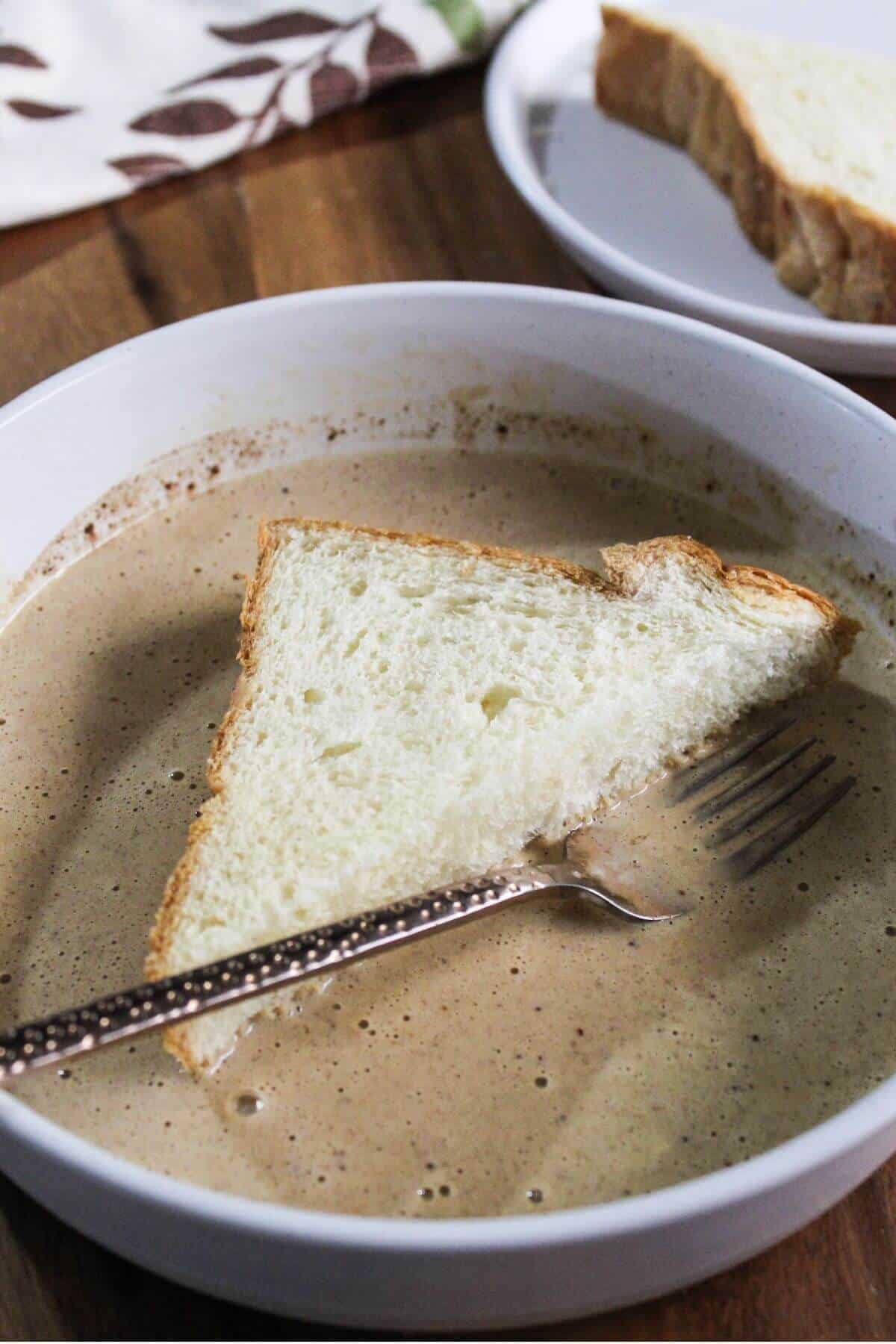 Soaking half slice of bread in egg mixture.