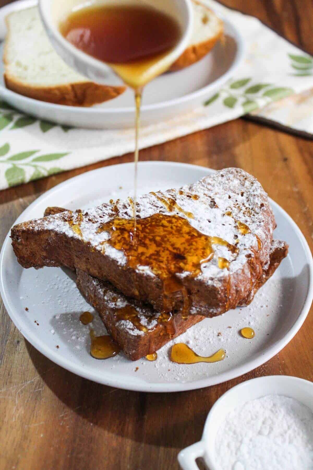 Pouring syrup over air fried french toast pieces.