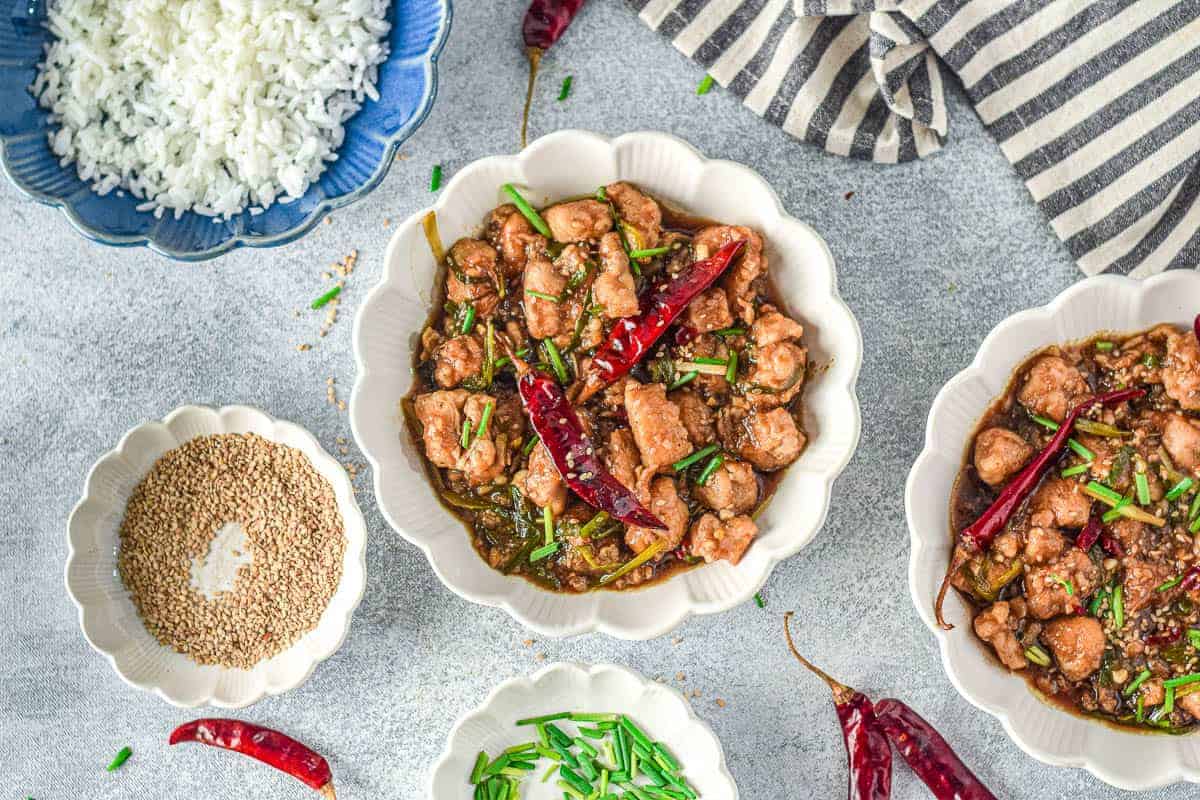 Mongolian chicken in bowls with ingredients.