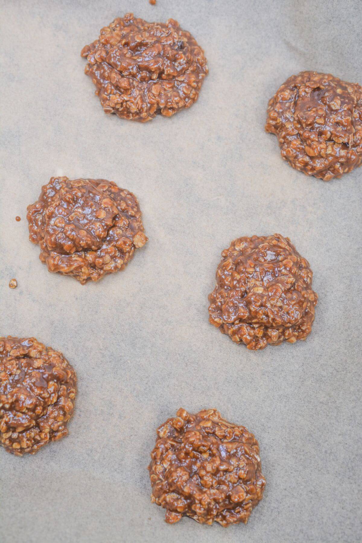 drops of no bake chocolate oatmeal cookie mixture onto parchment paper.