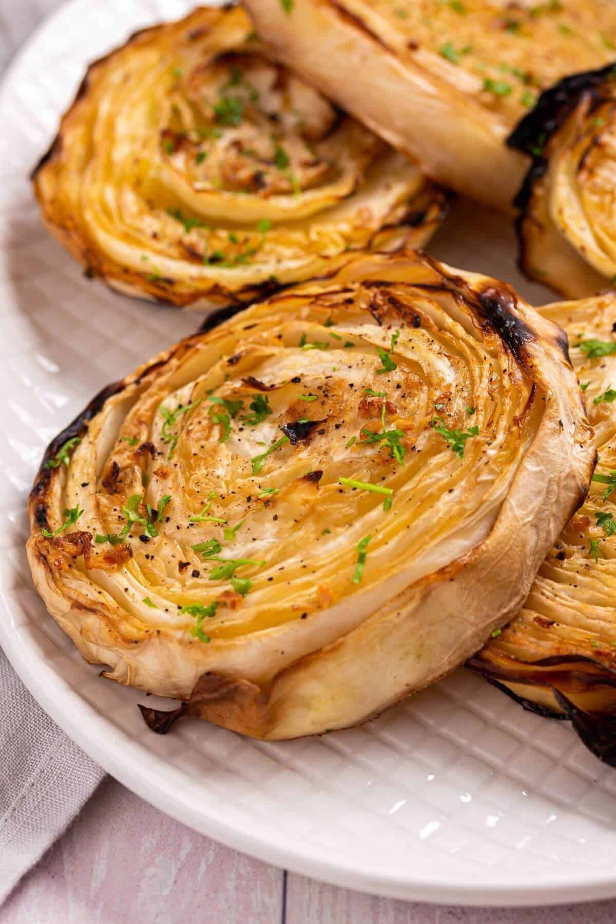 Closeup of cabbage steaks on platter.