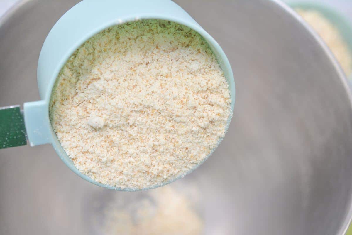 Adding almond flour to mixing bowl.