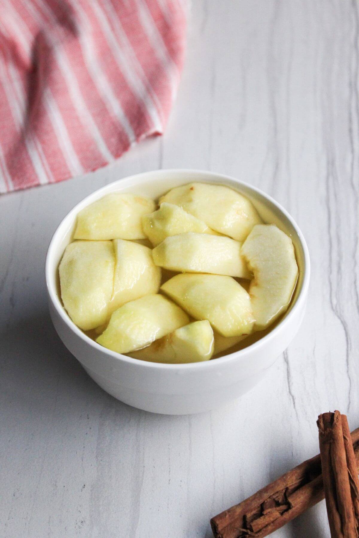 Apple slices in bowl of water.