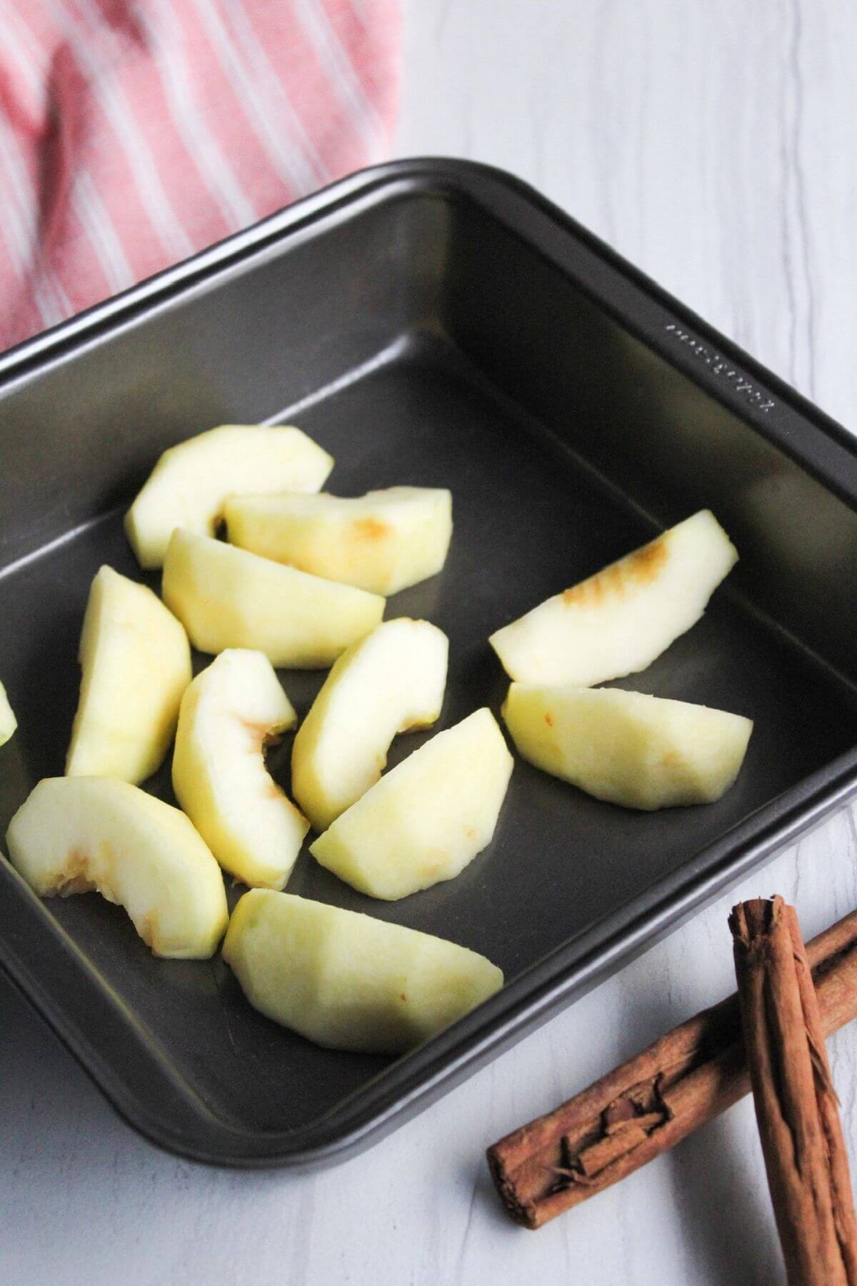Apple slices in square baking dish.