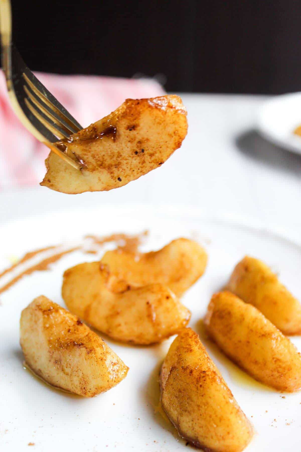 Air fryer apples on plate and fork.